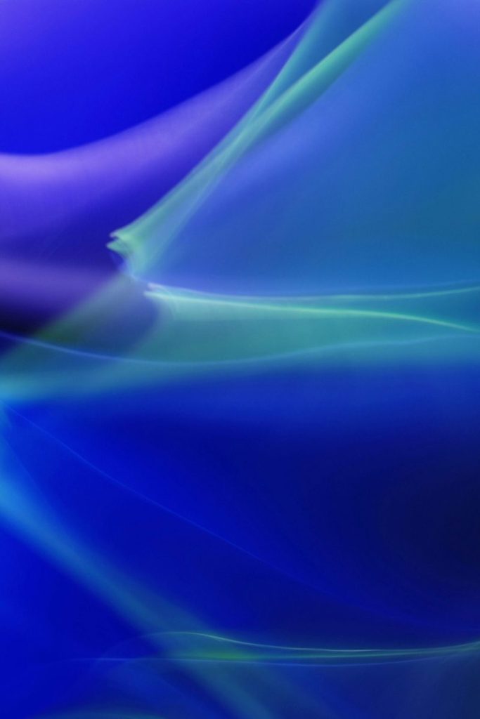 Abstract art featuring dynamic blue and green light waves creating an ethereal feel.